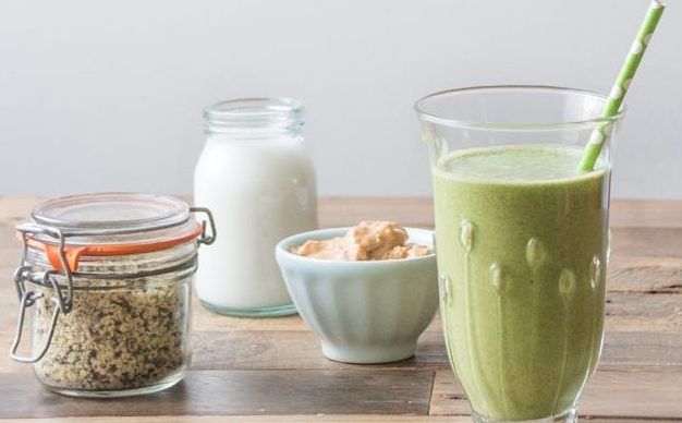 A green smoothie with oats and a jar of milk