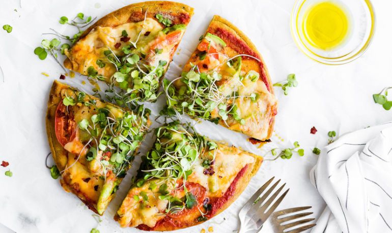 A pizza with a cauliflower crust, topped with vegetables