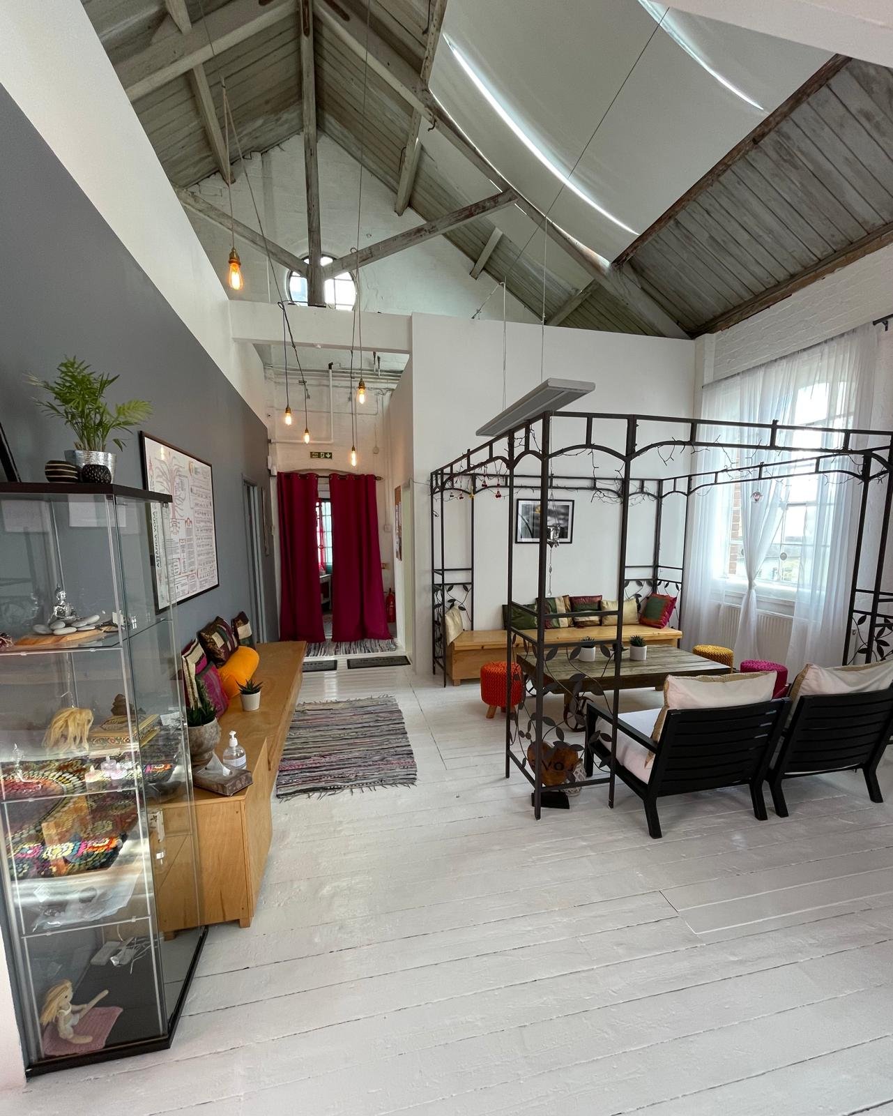 The lounge under the high wooden roof, with a bench, a table and armchairs